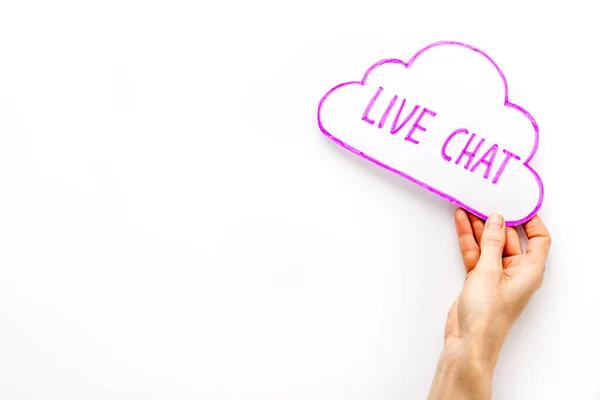 Live chat concept - bubble in hand on white desk top view