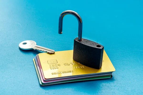credit card hacked. open lock on blue table
