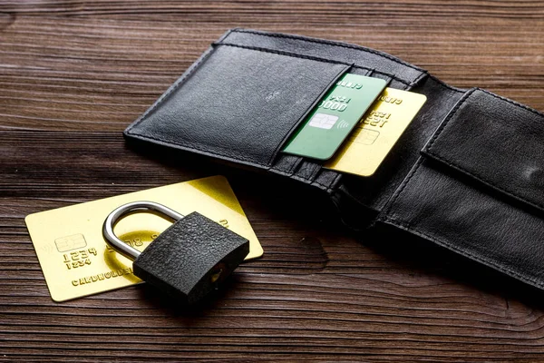 Credit card security concept with lock, wallet on wooden desk