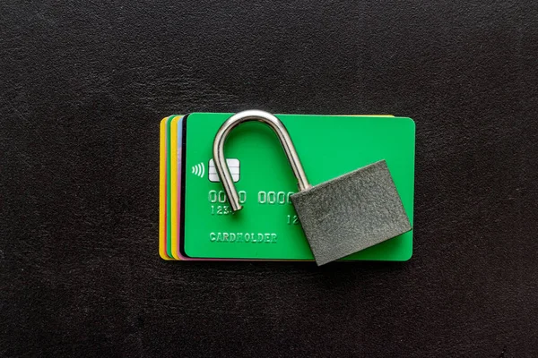 credit card hacked - security lock open - on black table top view