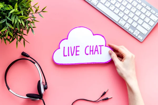 Live chat concept - bubble in hands on pink table top view