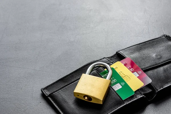 Credit card security concept with lock, wallet on grey desk copy space