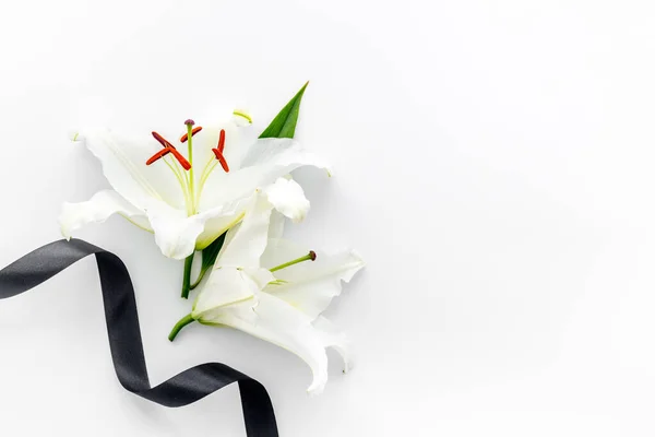 Funeral concept with lily and black ribbon, space for text