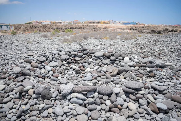 Circular Wall Built Stacked Pebbles Beach Blurry Buildings Background — Stock Photo, Image