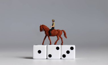  Beyaz zarlarla at süren minyatür bir adam..