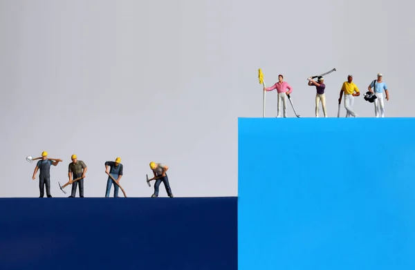 Miniature people. A concept on the gap between the rich and the poor.