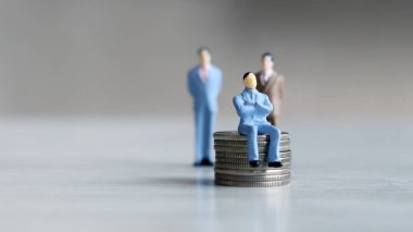 Para ve liderlik. Paranın üzerinde oturan adam ve arkasında duran iki adam..