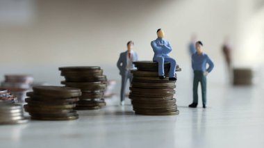 Paranın üzerinde oturan adam ve arkasında duran insanlar..