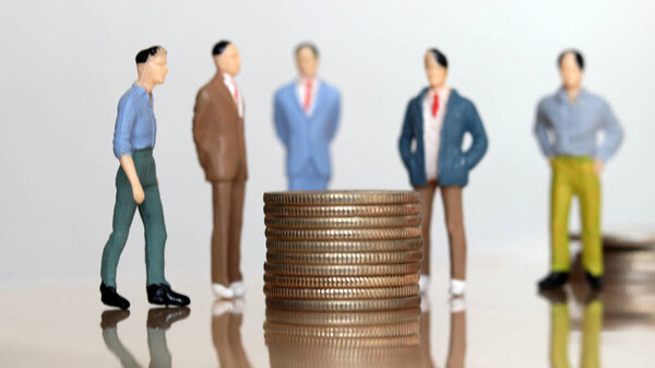 Money and human concept. People standing around a pile of coins.