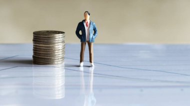 Minyatür İnsanlar ve Paralar. Haritada madeni para ve minyatür adam.