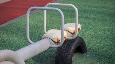 Yeşil arka planda çocuk parkında tahterevalli boş.