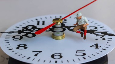 Saat iğnesinde oturan minyatür bir adam..