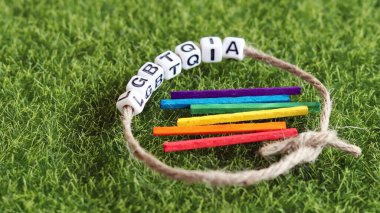 LGBTQIA metin ve gökkuşağı ahşap çubuklu bir ip.