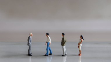 Sıranın sonundaki kadın. Minyatür insanlar sıra sıra diziliyor.