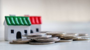 İki minyatür ev ve bozuk para yığını. 