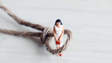 Çalışan kadınlara karşı sosyal adaletsizlik. Minyatür kadın ve ip.