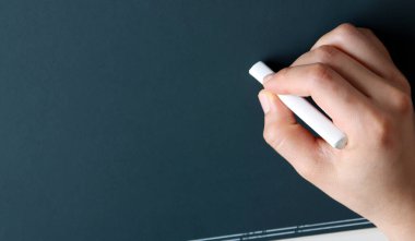 Elinde beyaz tebeşirle kamış tahtası.