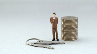 Orta yaşlı minyatür bir adam. Bir sürü anahtarı ve parası var..