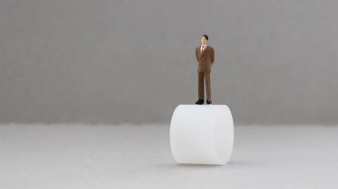 Yuvarlak bir fıçının üzerinde duran minyatür bir adam..