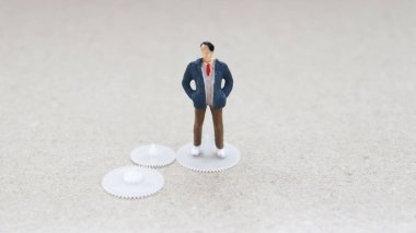 Yayların üzerinde duran minyatür bir adam.