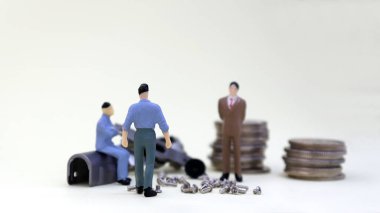 Çalışan işçi kavramı. Bir yığın minyatür insan ve bozuk para. Minyatür insanlar ve makine parçaları.