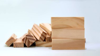 Yığılmış odun bloklarının önünde üç tahta blok yığını.