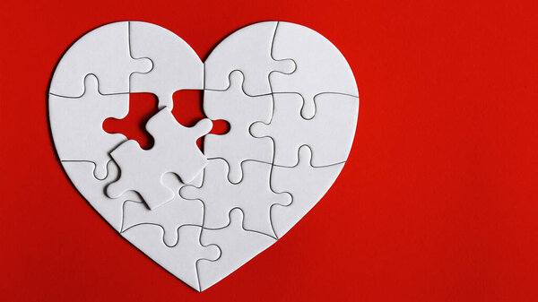 Puzzles in the shape of a white heart on the red background.