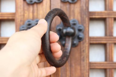 Geleneksel kapının kapı tokmağını kavramak.