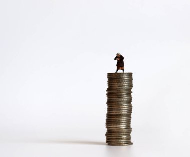 Bozuk paralarla dolu minyatür insanlar. Yaşlılık ve para kavramı.