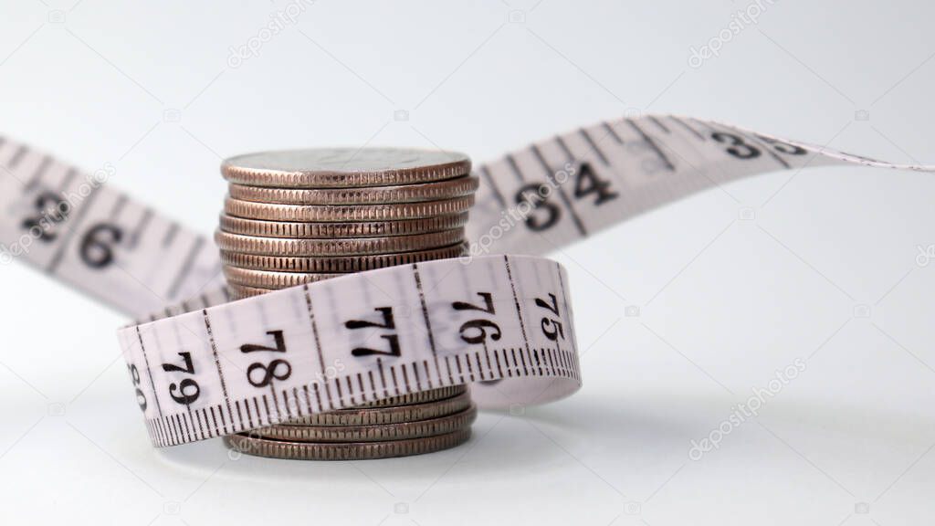 A pile of coins wrapped tape measure.