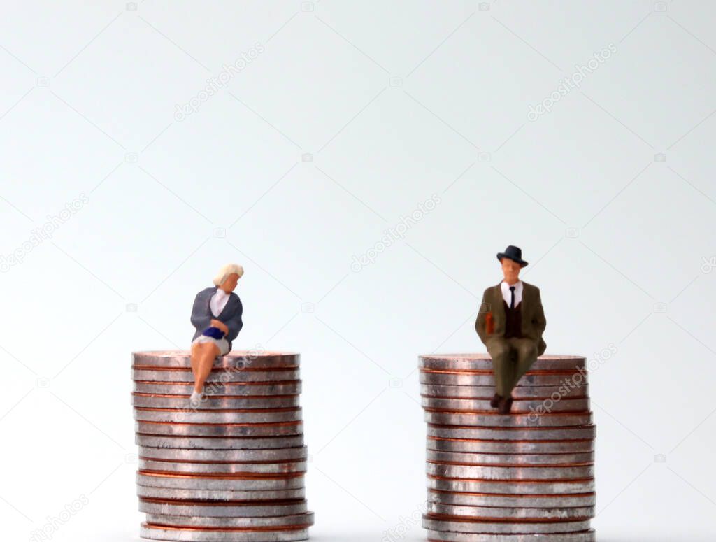An equal pay concept. Miniature people sitting in the same height pile of coins.
