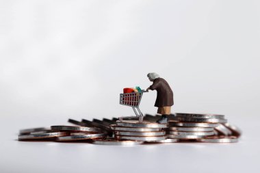 Bozuk para yığınına el arabası çeken minyatür bir kadın..
