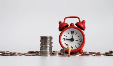 Minyatür bir kadın elinde bozuk paralarla alışveriş arabasını çekiyor..