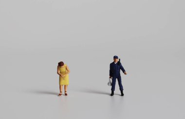 Minyatür erkek polis minyatür bir kadınla yan yana duruyor..