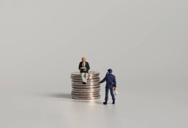 Bozuk para okuyan minyatür bir adam ve elinde megafon tutan minyatür bir polis..