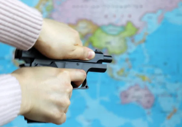 Обе Руки Женщины Пистолетом Фоне Карты Мира — стоковое фото