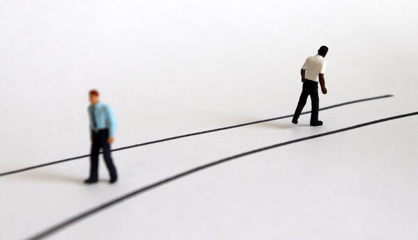 Miniature people walking in different directions.