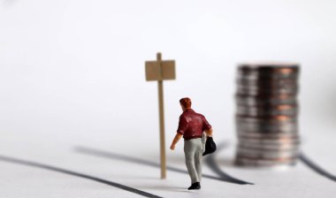 İki yönlü ve minyatür bir adam. Minyatür insanlar ve madeni paralar.