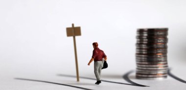 İki yönlü ve minyatür bir adam. Minyatür insanlar ve madeni paralar.