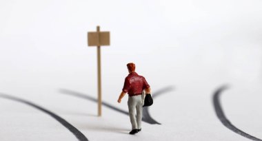 İki yönlü ve minyatür bir adam. İki yol ve bir tabela..