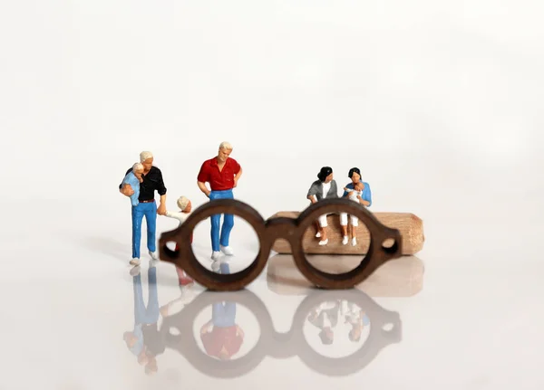 Miniature people and miniature glasses. The concept of a discriminatory gaze of gay couples' families.