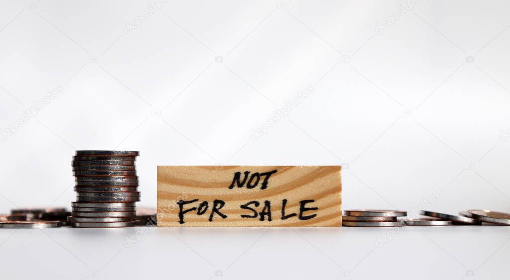 Not for sale campaign. Coins and block of wood.