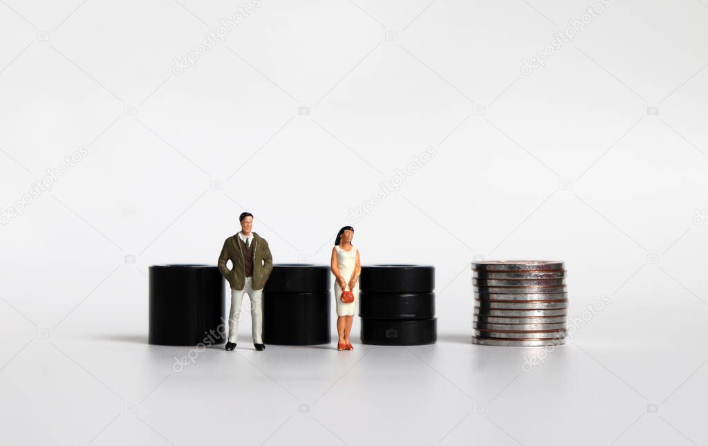 Equal labor equal pay concept. Miniature woman and a miniature man. 