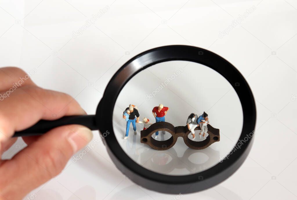 Magnifier and miniature people. The concept of people's narrow view of gay marriage and family.