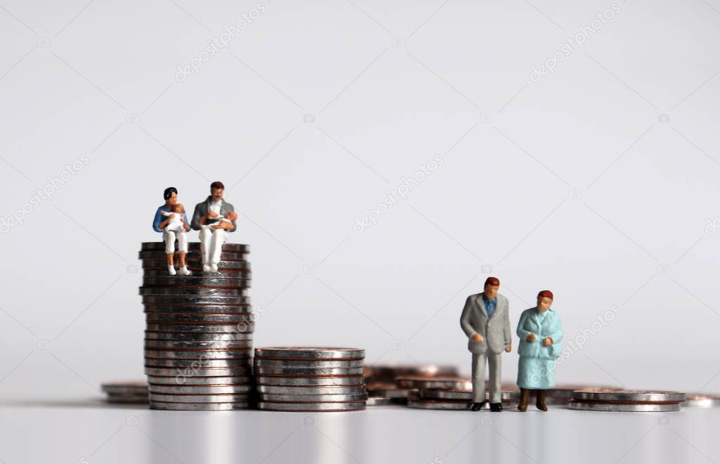 Coins and miniature people. The concept of income and generation gap.