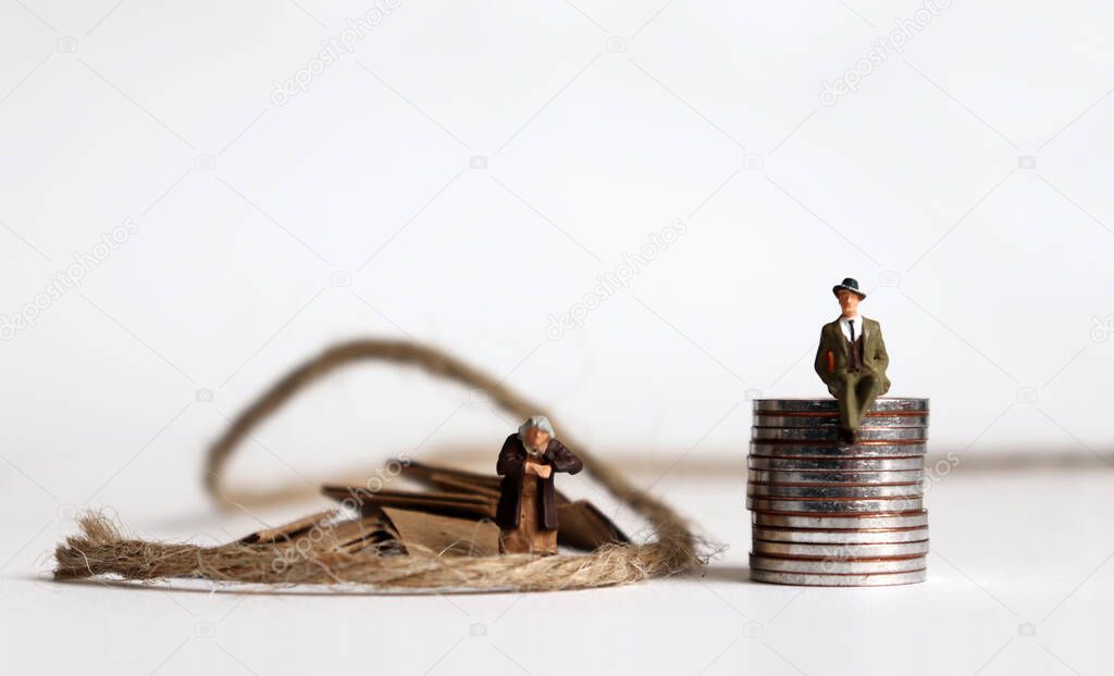 Coins with miniature people. The concept of the generation gap between rich and poor.