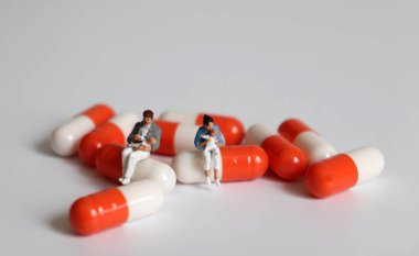 Minyatür bir kadın ve minyatür bir adam kapsülde bebek tutuyorlar..