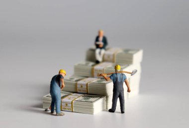 Minyatür insanlar. Banknotlar merdiven şeklinde..