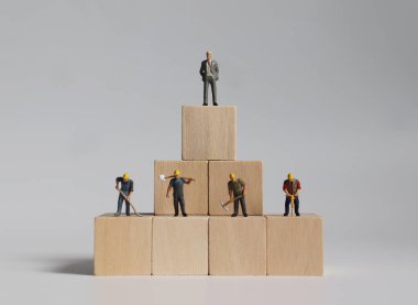 Tahta bloklar ve minyatür insanlar. Sosyal sınıflandırma kavramı.