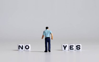 Evet ya da hayır konsepti. Beyaz metin küpü ve minyatür insanlar.